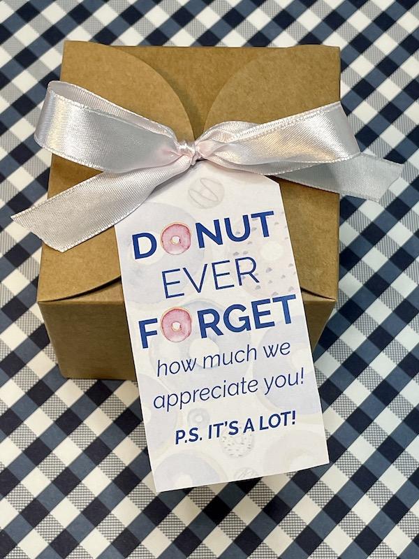 printable appreciation gift tags for teachers with doughnut theme with pastel pink, purple and tan color scheme on top of Kraft colored and ribbon tied gift box atop of blue and white gingham background