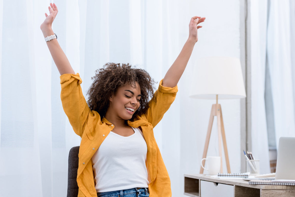 woman with raised arms in a satisfied, content face